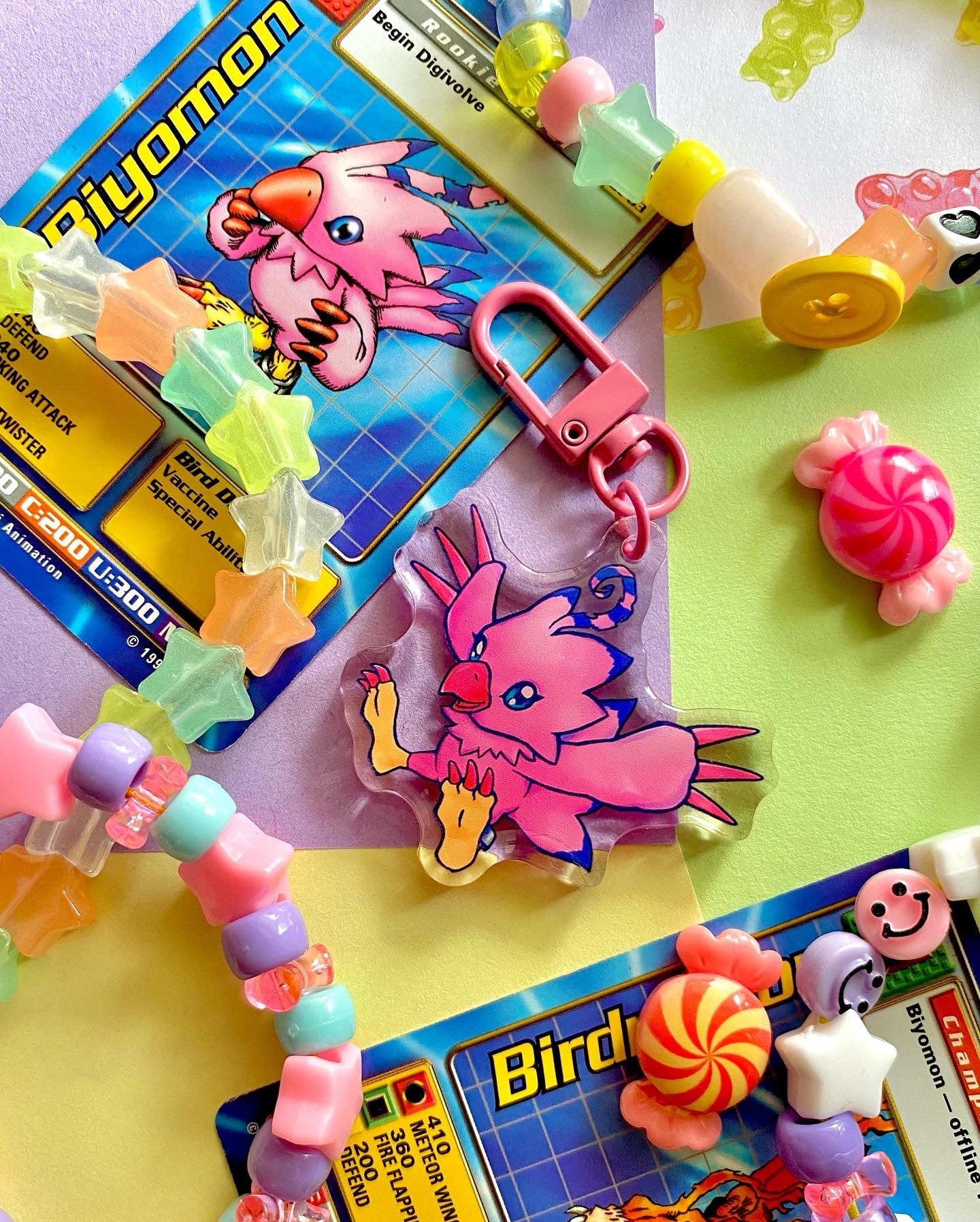 image features one keychain featuring original artwork by candy critters.
details in the background of the product photo contains a collage of trading cards, candy charms, and a kandi bracelets. (background items not included in purchase of keychain)
keychain is double sided with same design on both sides. features a drawing of a pink bird with her wings stretched out.
the hardware for this keychain is pink.