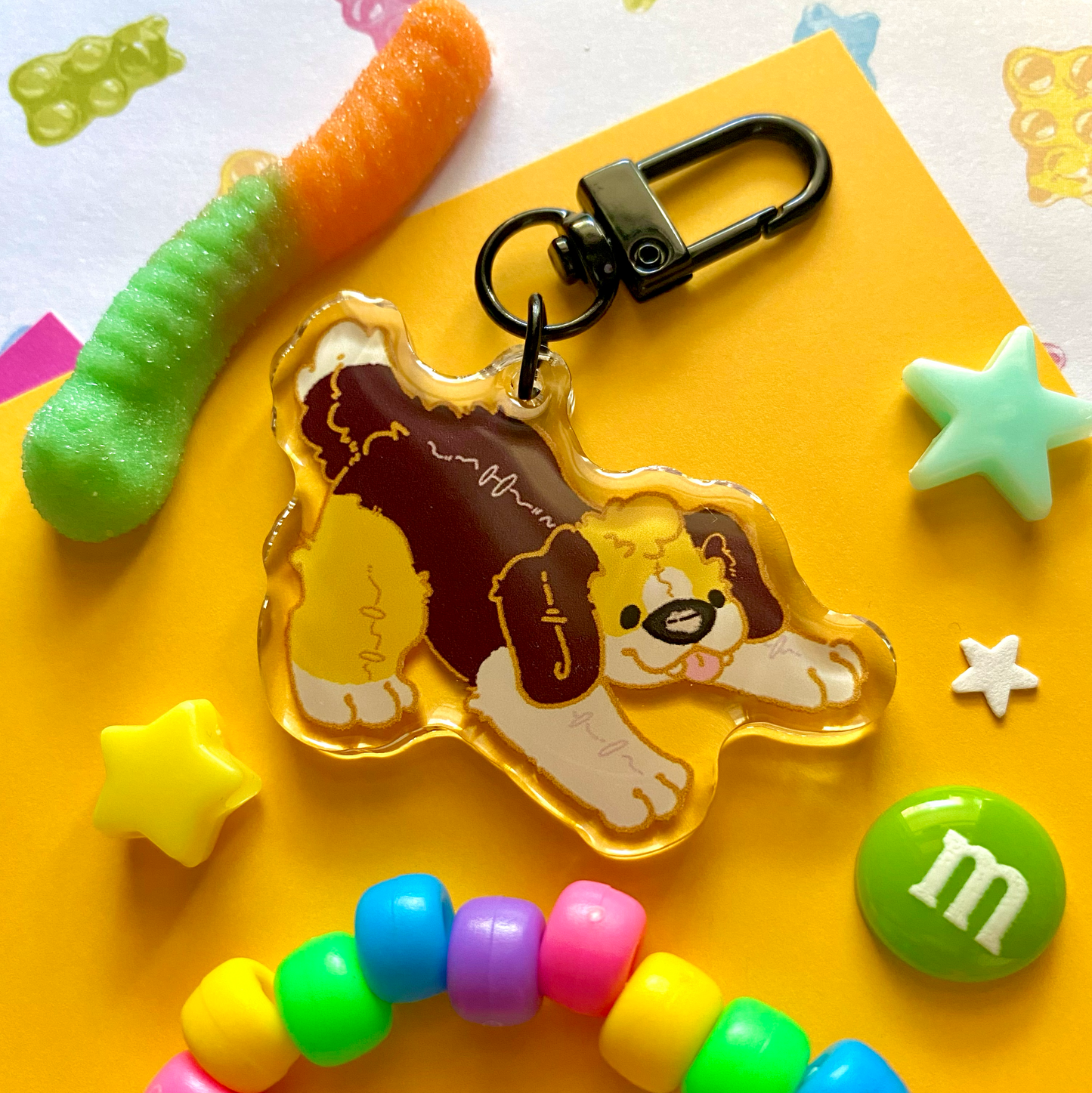 image features one keychain featuring original artwork by candy critters. 
details in the background of the product photo contains a gummy worm, star charms, a candy charm, and a kandi bracelet. (background items not included in purchase of keychain)

 keychain is double sided with the same design on both sides. featuring a drawing of a brown, yellow, and white plushie beagle fursona.
the hardware for this keychain is black.