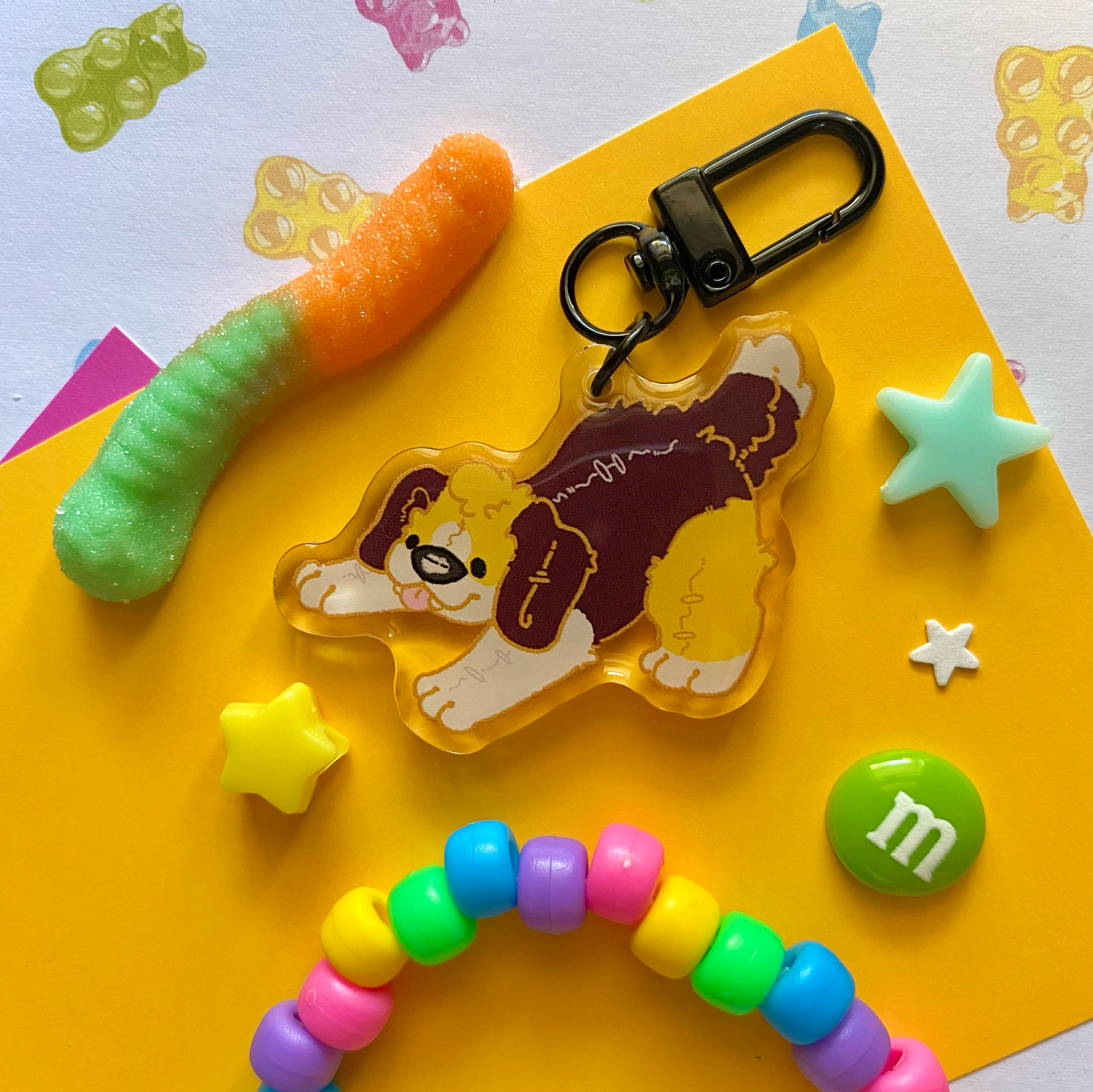 image features one keychain featuring original artwork by candy critters. 
details in the background of the product photo contains a gummy worm, star charms, a candy charm, and a kandi bracelet. (background items not included in purchase of keychain)

 keychain is double sided with the same design on both sides. featuring a drawing of a brown, yellow, and white plushie beagle fursona.
the hardware for this keychain is black.